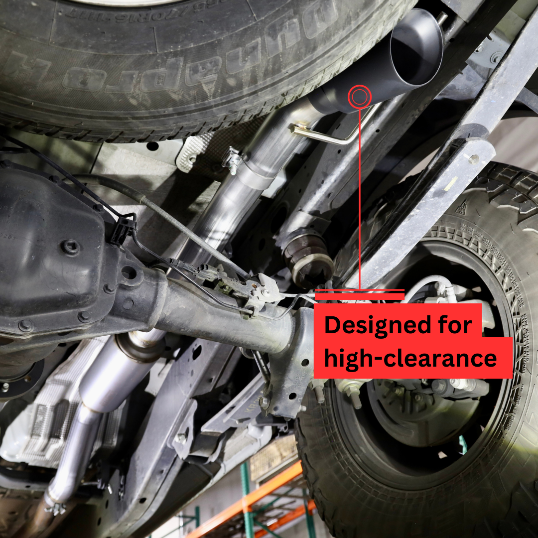 A close up of an installed 2019-2023 Ford Ranger Over Axle Carven Exhaust Dump Kit on the underside of a vehicle with text that says "Designed for high-clearance"