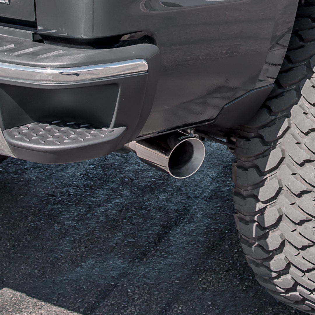 A close up of aCarven Exhaust 4.00" Universal Bolt-On Exhaust Tip in polish color installed on a truck