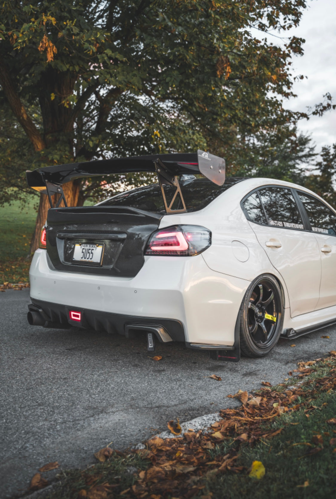 The backside of a parked white and black Subaru car with an installed 2015-2021 Subaru WRX & STI Carven Exhaust Single Exit Exhaust System