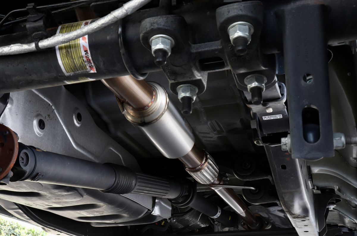 The underside of a vehicle with an installed 2015-2020 Ford F-150 EcoBoost Carven Exhaust Cat-Back Kit