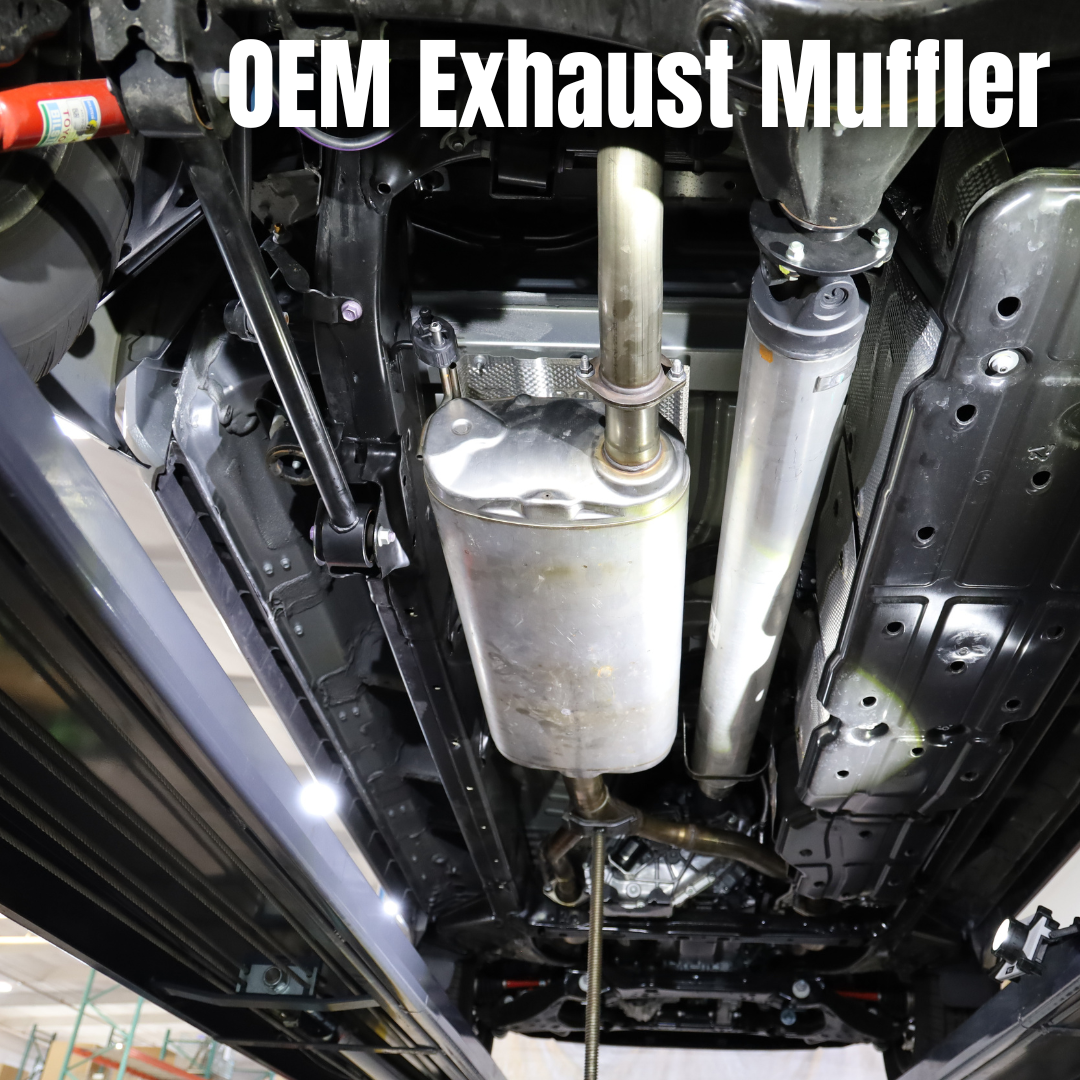 The underside of a vehicle with an OEM exhaust muffler and text that says "OEM Exhaust Muffler"