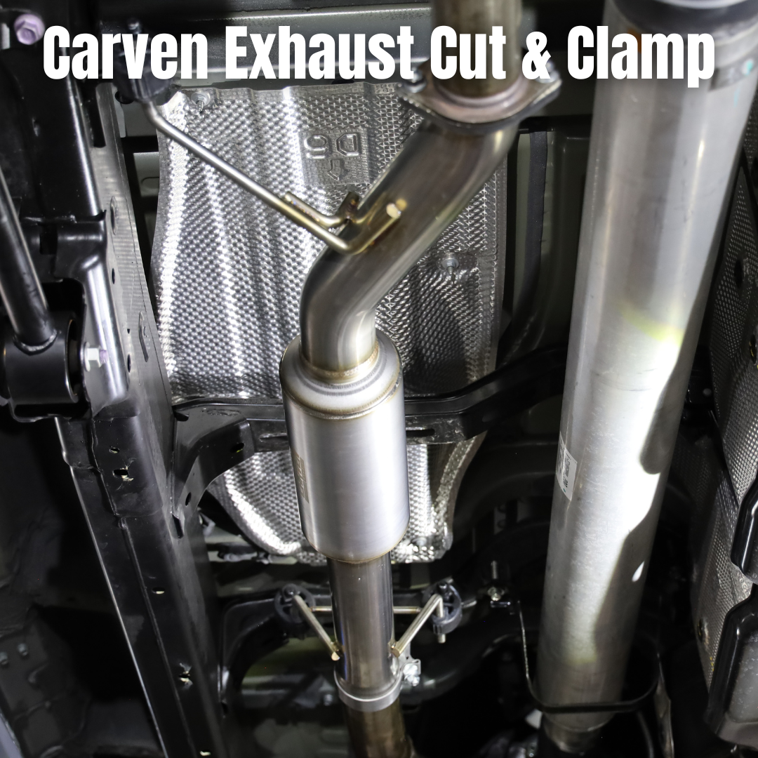 The underside of a vehicle with an installed 2022-2025 Toyota Tundra Carven Exhaust Cut & Clamp Muffler Replacement Kit with text that says "Carven Exhaust Cut and Clamp"