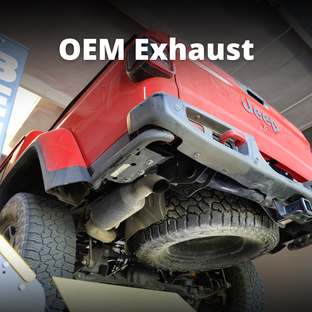 The underside of a red Jeep with an OEM exhaust and text that says "OEM Exhaust"
