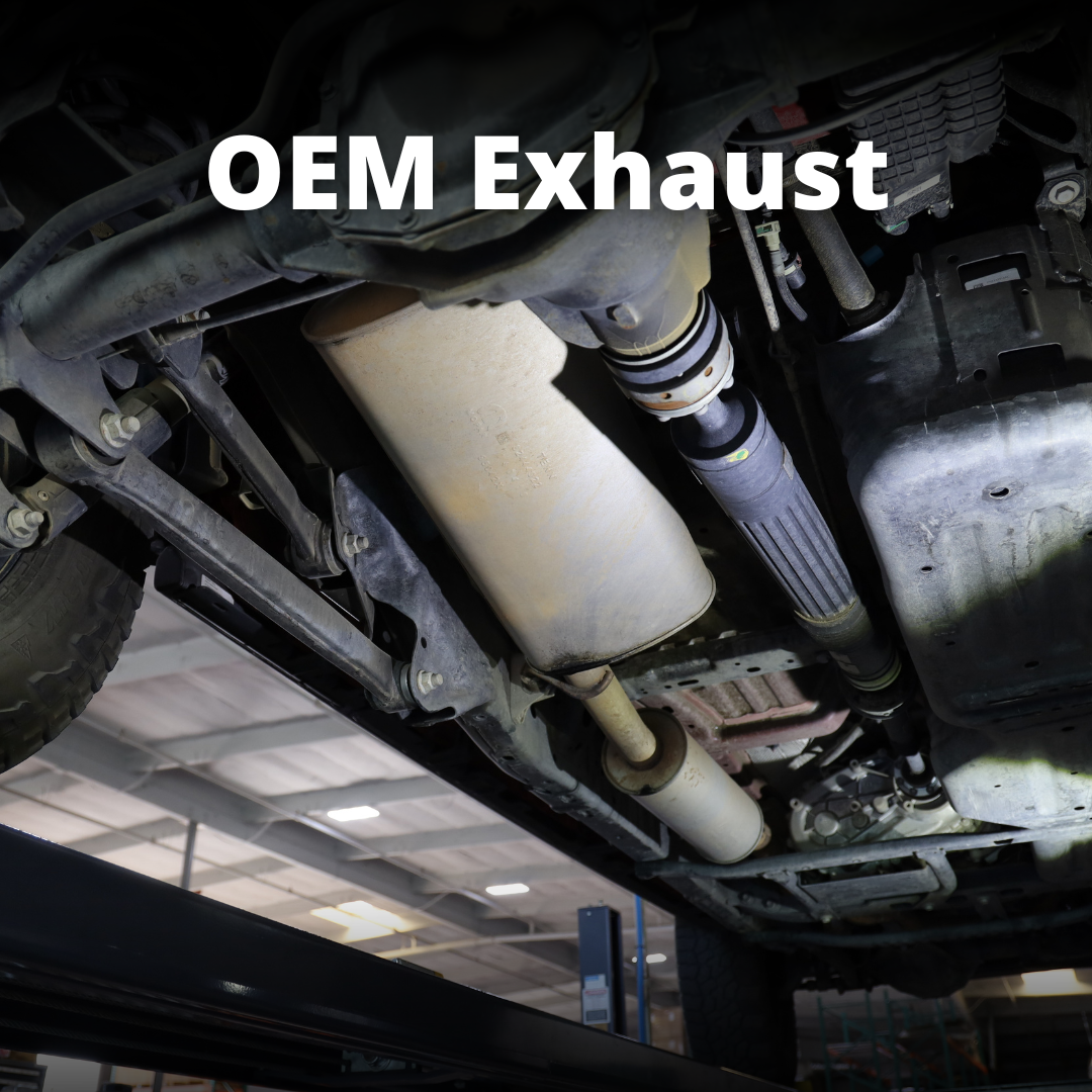 A close up of an OEM exhaust on the underside of a vehicle and text that says "OEM Exhaust"