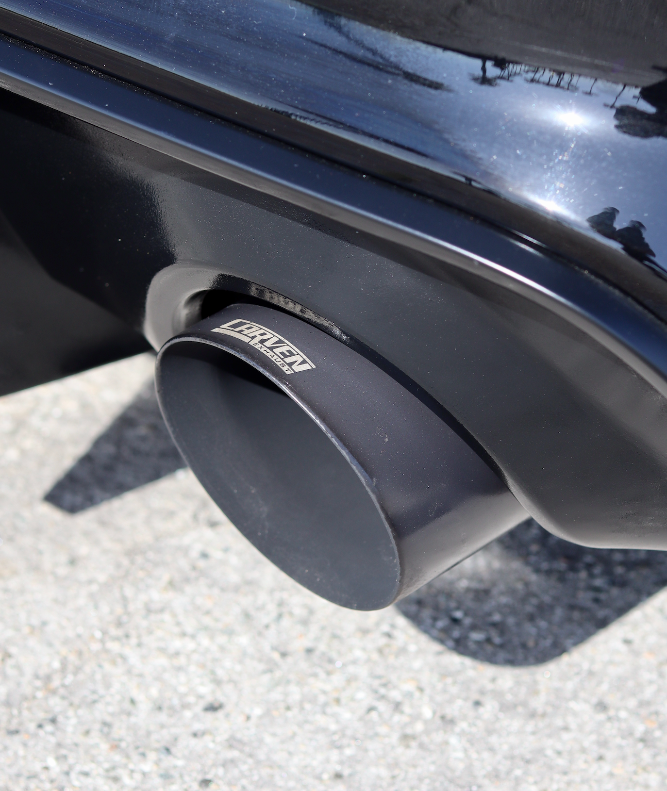 Close up of an installed 2015-2023 Dodge Charger Carven Exhaust 5.0" Tip Replacement Set in the ceramic coated black color