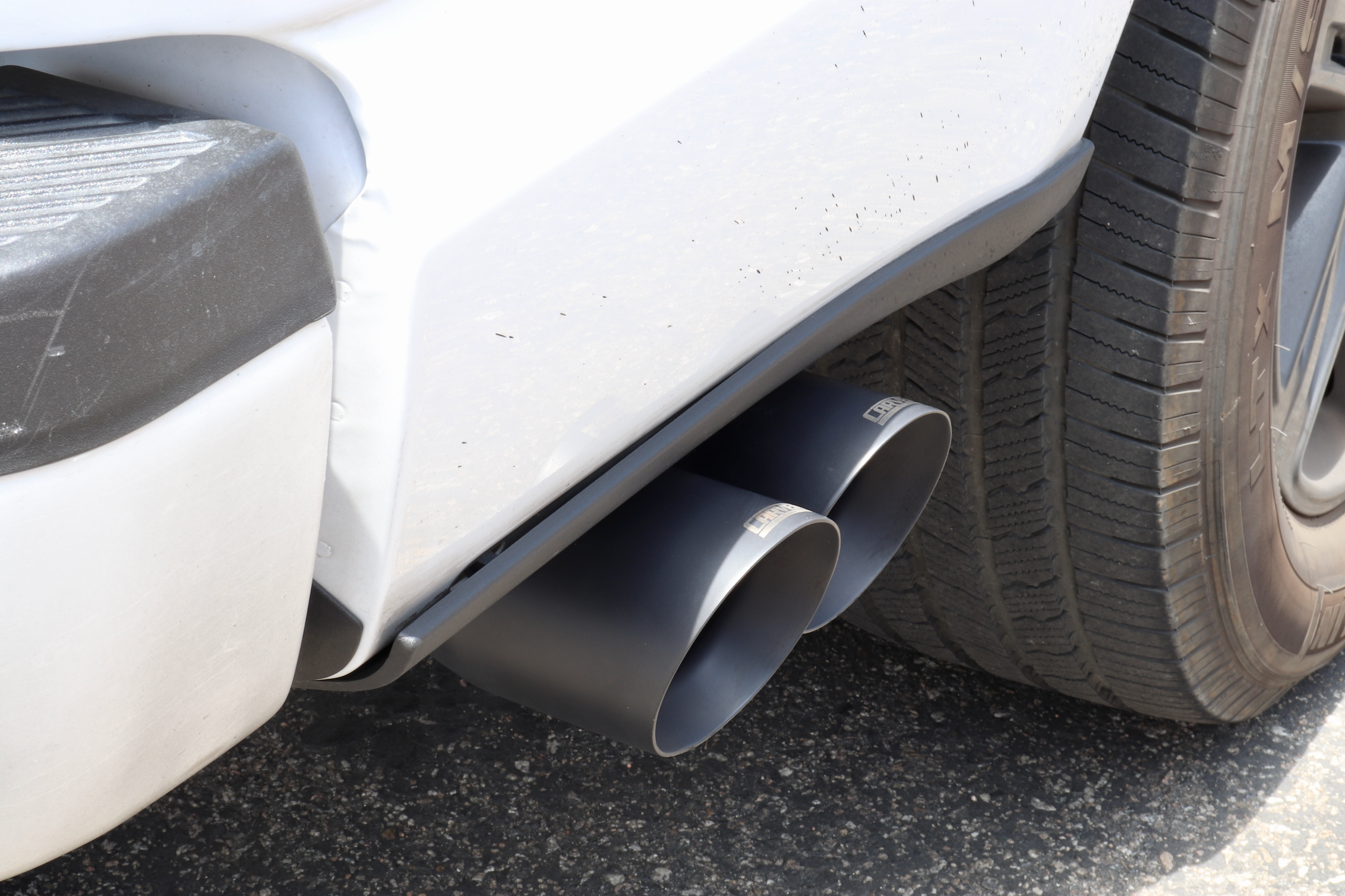 Close up of a white Ford F-150 truck with an installed Cerkaote black 4" Dual Exit Tip