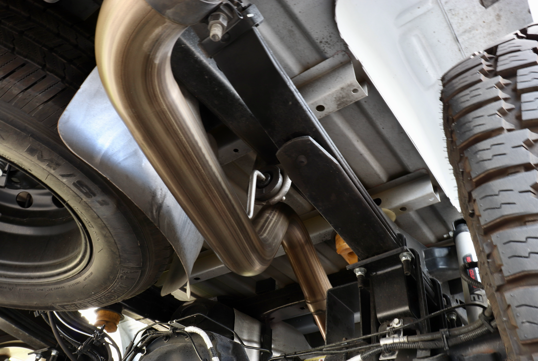 The underside of a vehicle with an installed 2015-2020 Ford F-150 EcoBoost Carven Exhaust Cat-Back Kit