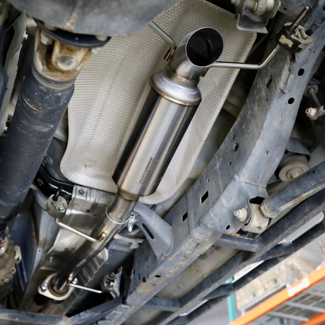 The underside of a vehicle with an installed 2003-2024 Toyota 4Runner Carven Exhaust High Clearance Dump Exit Exhaust System 