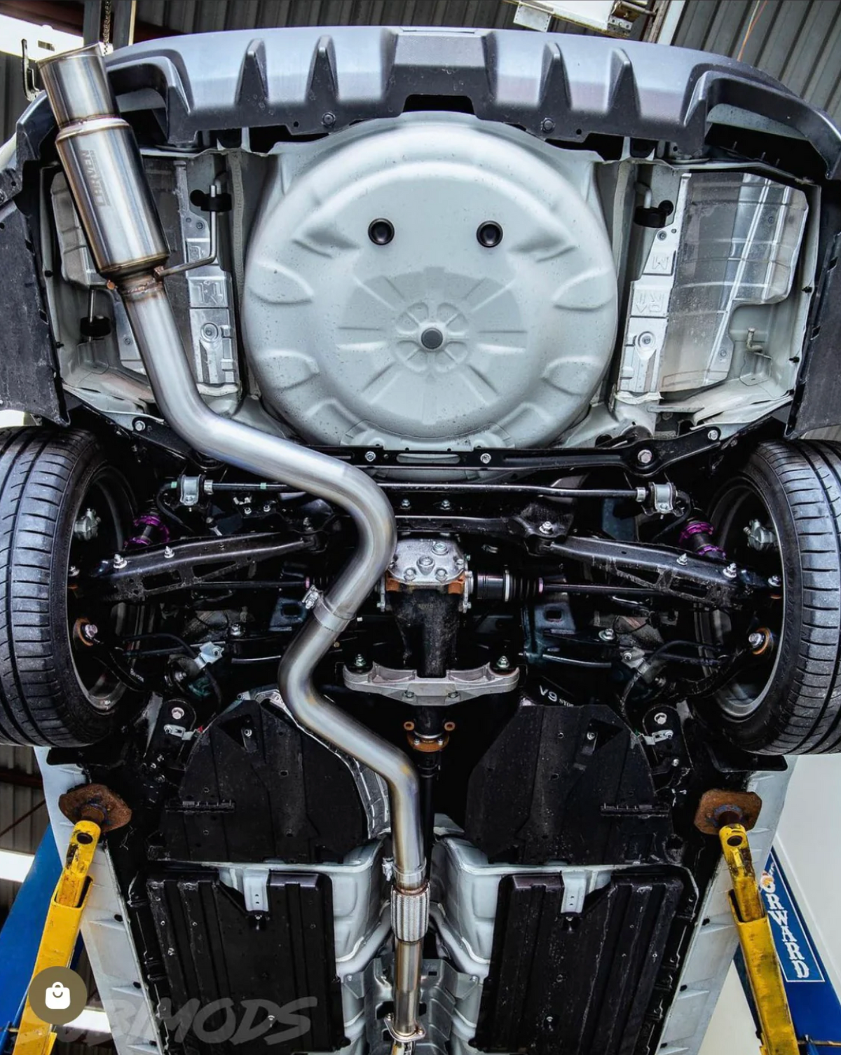 The underside of a Subaru car with an installed 2015-2021 Subaru WRX & STI Carven Exhaust Single Exit Exhaust System with a polished stainless finish