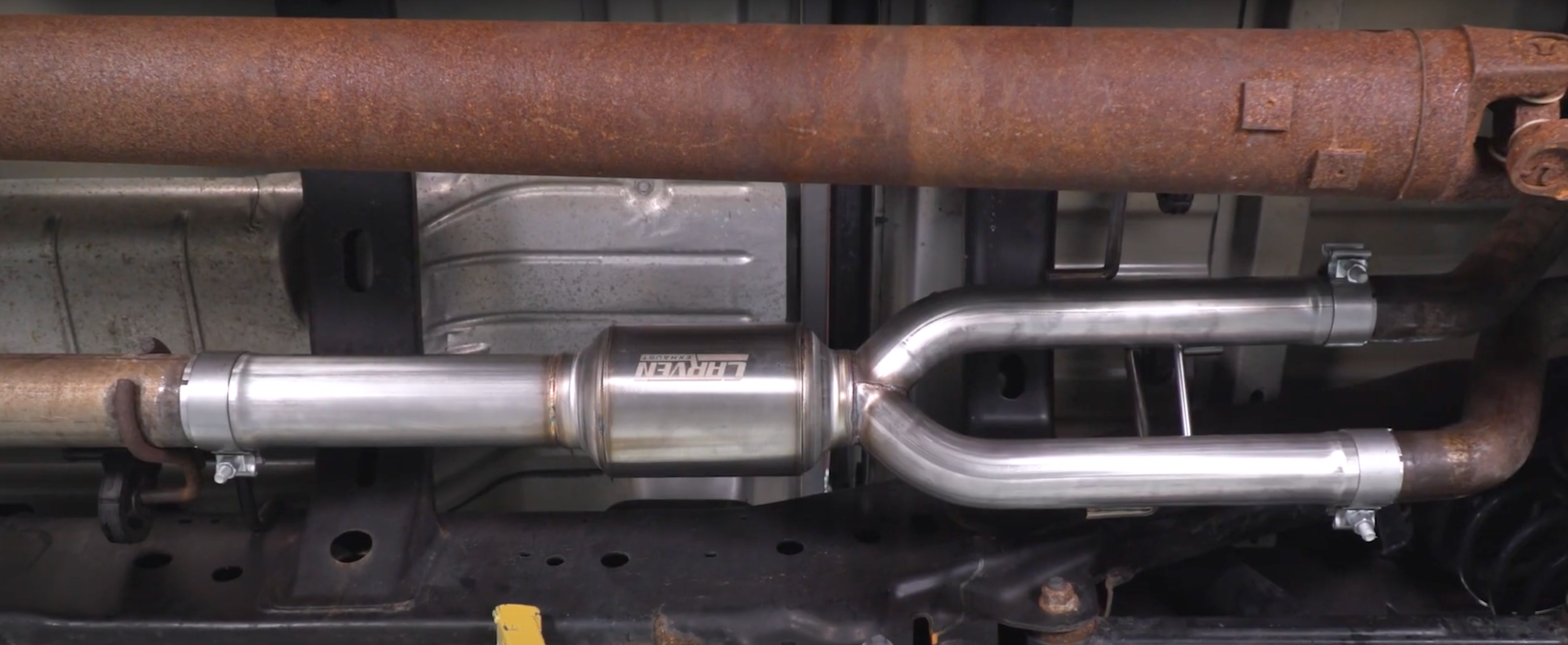 The underside of a vehicle with an installed 2009-2018 RAM 1500 Carven Exhaust Direct Fit Muffler Replacement Kit 